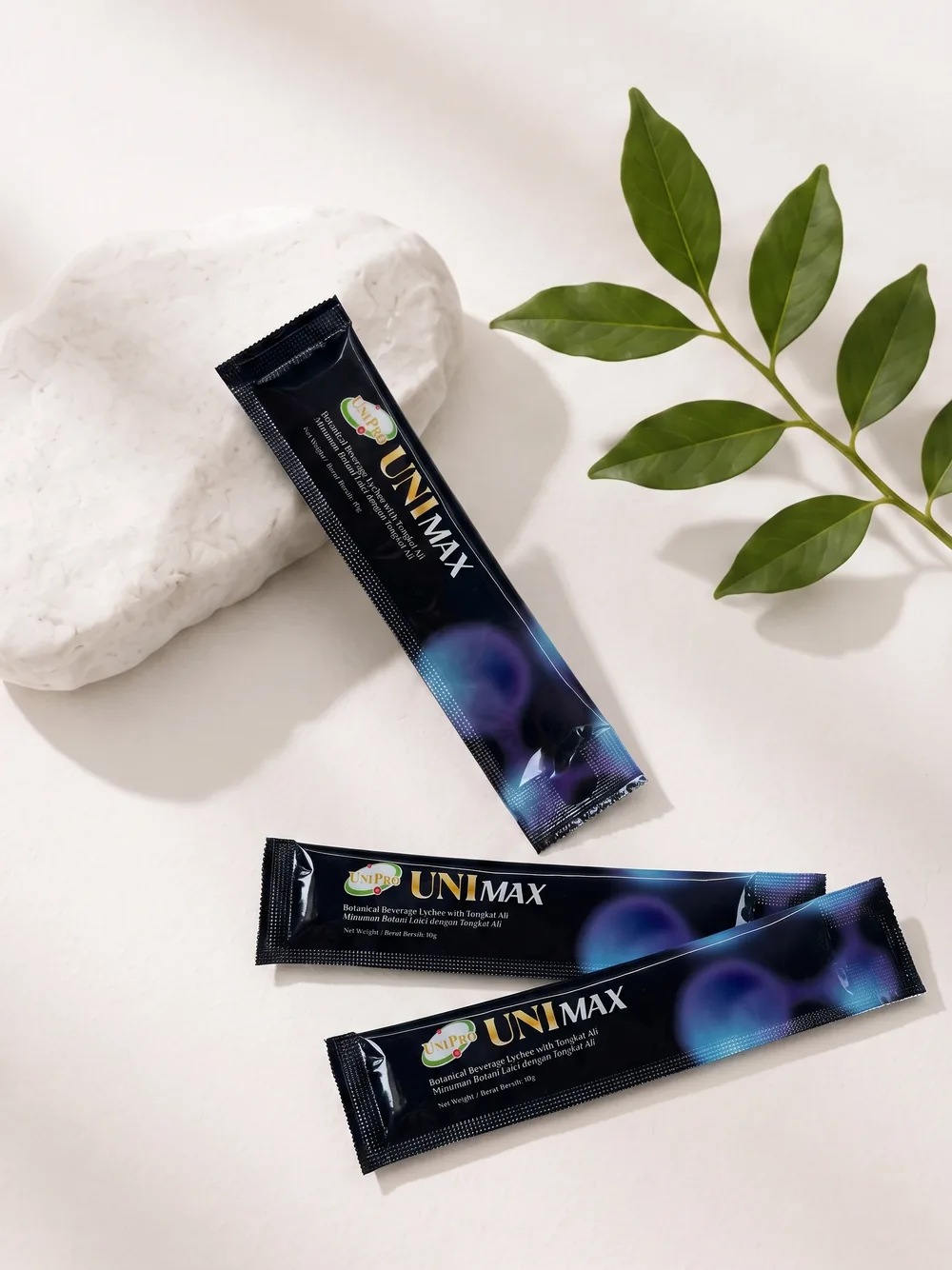 UNI MAX 10g sachets flat-laid with a botanical sprig