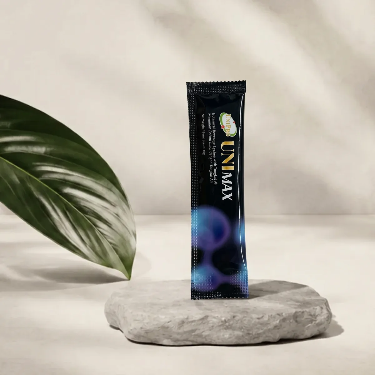 UNI MAX 10g sachet standing on a stone podium with a botanical leaf